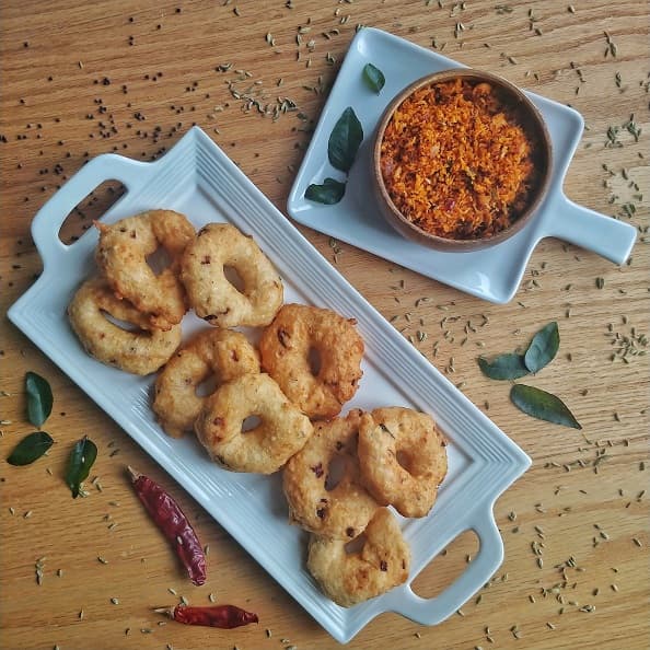 Ulundu vadai with Coconut sambol on a Table