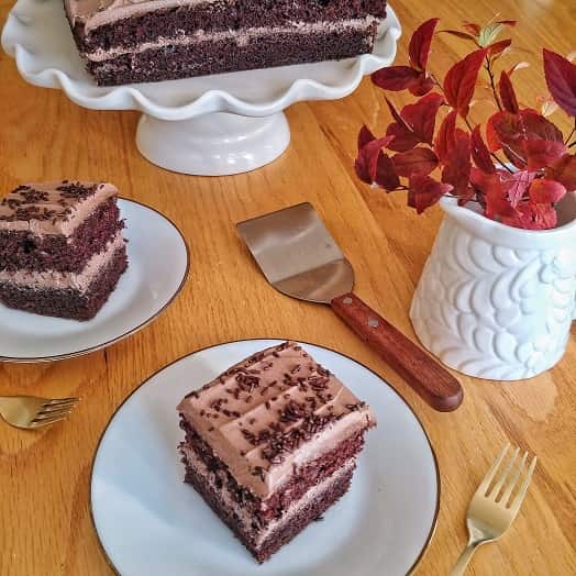 Chocolate cake on the table with a slice of cake .