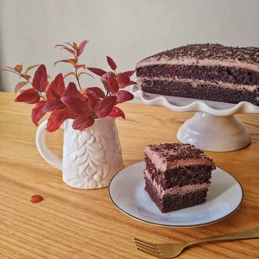 Chocolate cake on the table with a slice of cake .