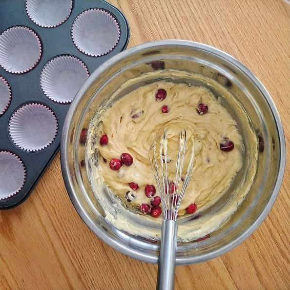 Cranberry Orange Muffin batter ready to be scooped into baking tray with fresh cranberries.