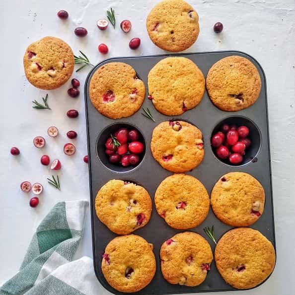Cranberry Orange Muffin on baking tray with fresh cranberries.