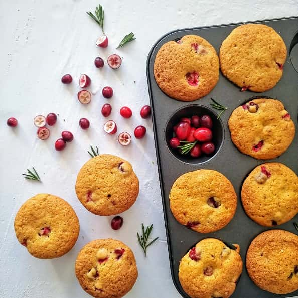 Cranberry Orange Muffin on baking tray with fresh cranberries.