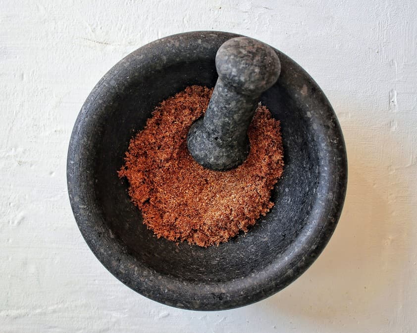 Roasted coconut and spices grounded using a Mortar and pestle.