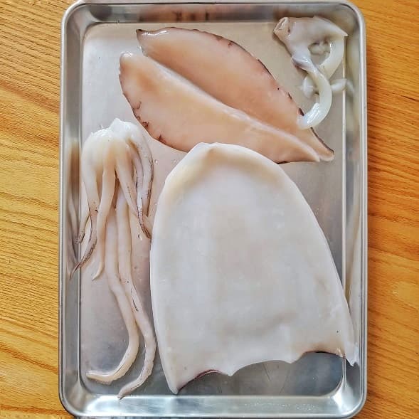 Cleaned Squid on a tray ready to be cut into bit size pieces for cooking.