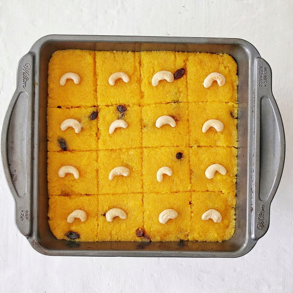 Dairy free rava Kesari on a baking tray, sliced.